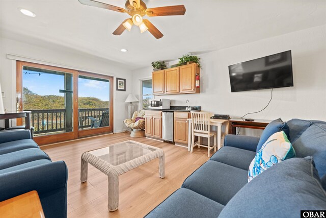 living area with recessed lighting, ceiling fan, wet bar, and light wood finished floors