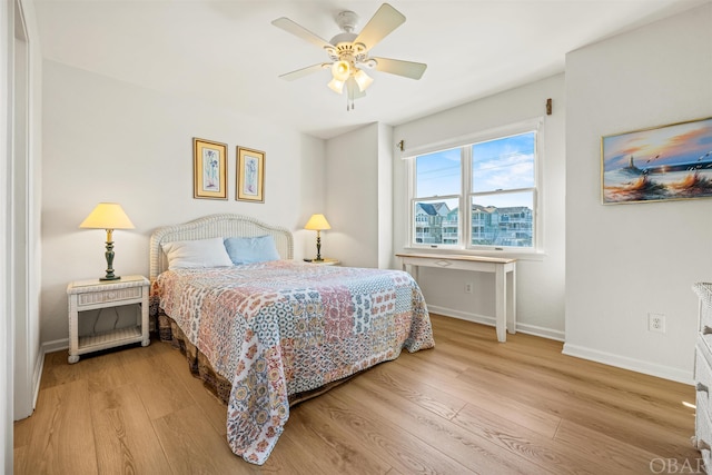 bedroom featuring baseboards, a ceiling fan, and light wood-style floors