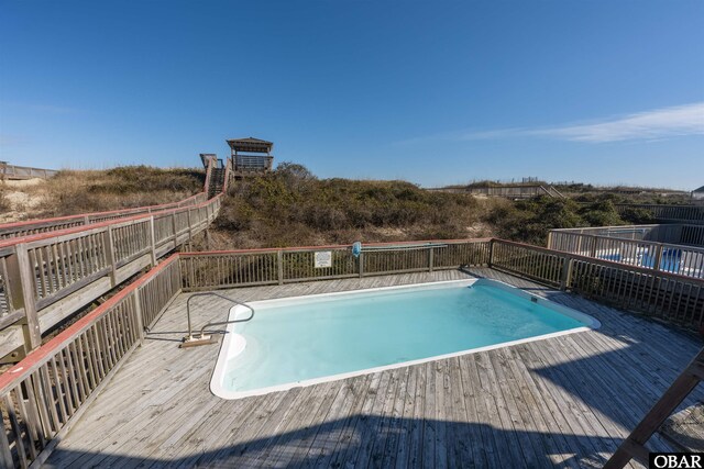 view of swimming pool with a fenced in pool and a wooden deck