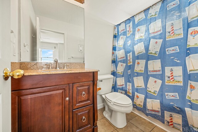 bathroom featuring curtained shower, tile patterned flooring, toilet, vanity, and baseboards