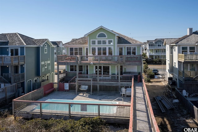 back of property featuring a deck and a community pool