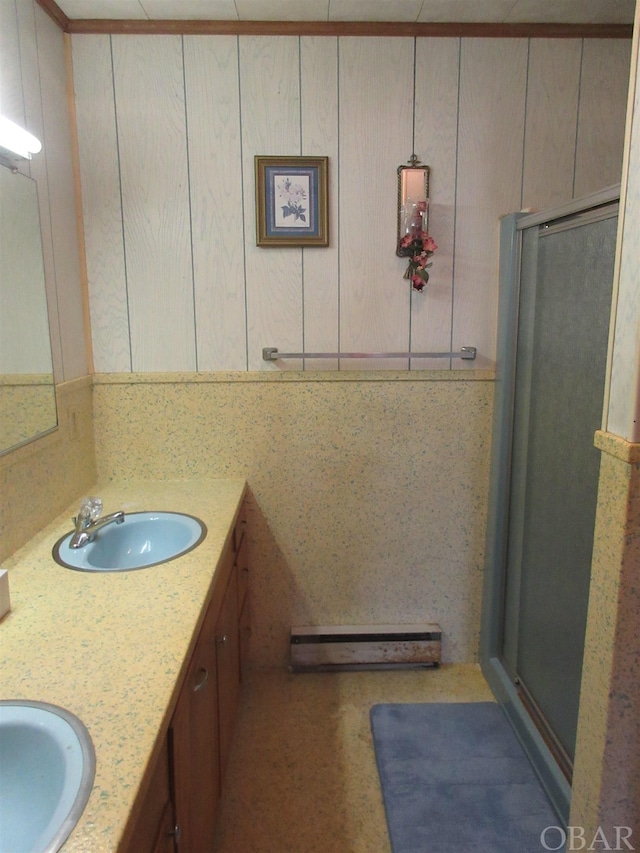 bathroom featuring double vanity, a stall shower, and a sink