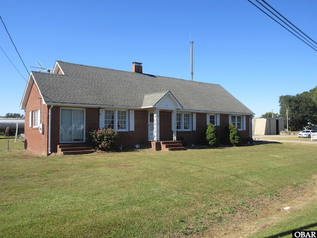 single story home with entry steps, roof with shingles, and a front yard