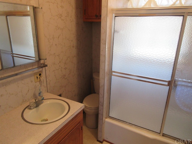 full bath featuring toilet, wallpapered walls, enclosed tub / shower combo, and vanity