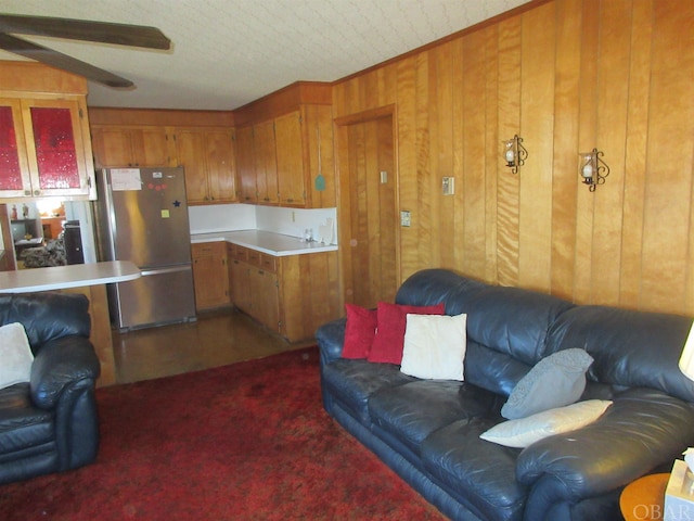 carpeted living area featuring wooden walls