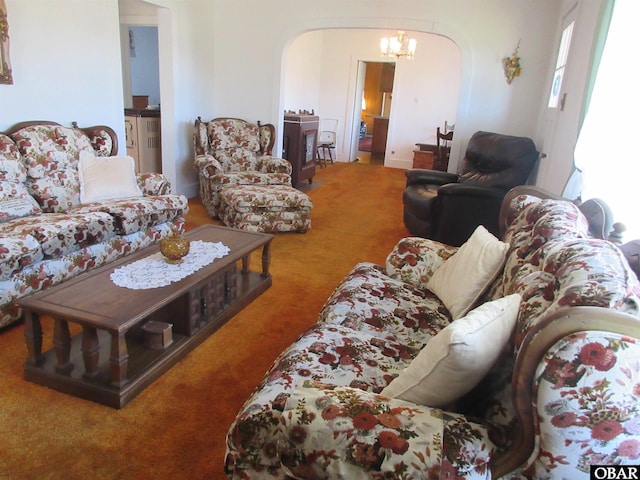 living area featuring carpet, arched walkways, and a chandelier