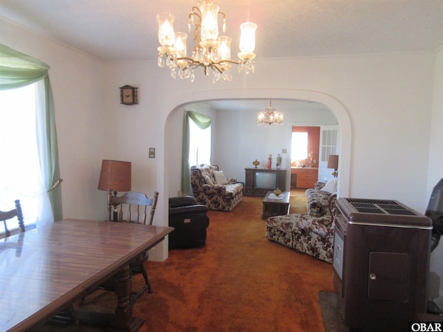 dining area featuring carpet floors, arched walkways, and a notable chandelier