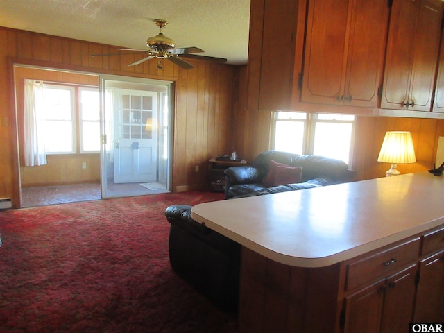 kitchen with light carpet, light countertops, open floor plan, and wooden walls