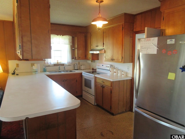 kitchen featuring white electric range, a sink, light countertops, freestanding refrigerator, and brown cabinets