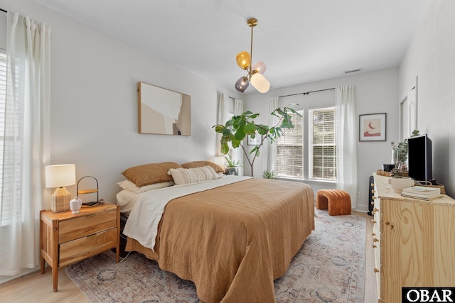 37 Foxwood Cir Lot # 33, Southern Shores, NC 27949 - bedroom featuring light wood-type flooring and a chandelier