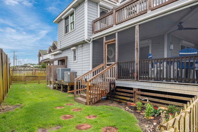 exterior space featuring cooling unit, fence, and a lawn