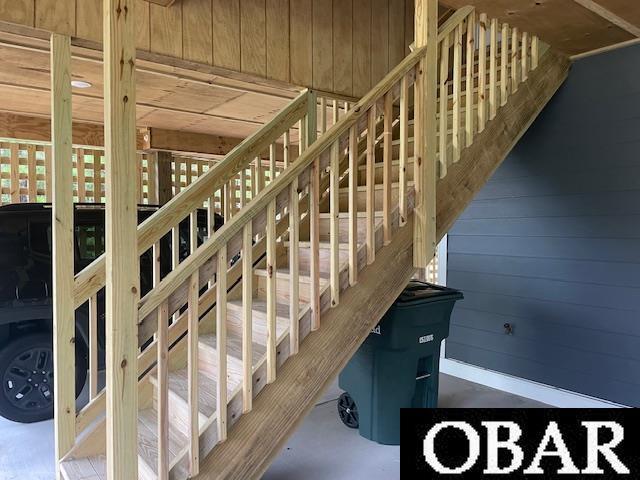 stairway featuring wooden walls