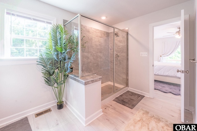 bathroom with wood finished floors, visible vents, baseboards, a shower stall, and ensuite bath