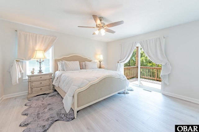 bedroom with access to exterior, multiple windows, baseboards, and wood finished floors