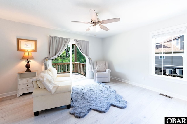 sitting room with ceiling fan, wood finished floors, visible vents, and baseboards