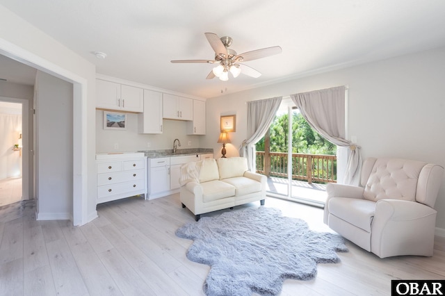 interior space featuring light wood-style floors, baseboards, and a ceiling fan