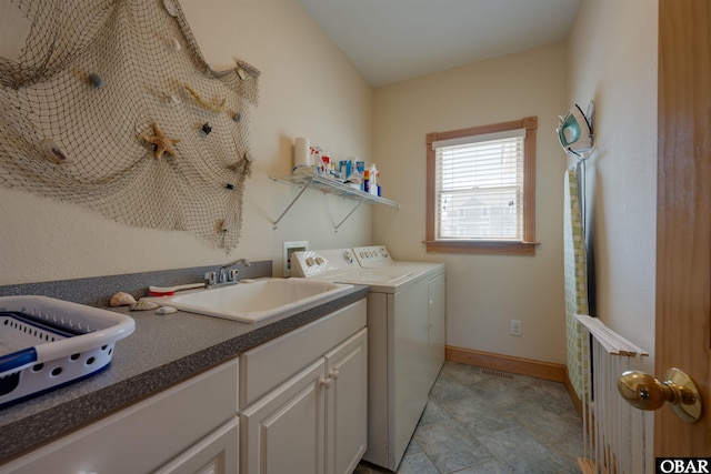 clothes washing area with independent washer and dryer, a sink, cabinet space, and baseboards