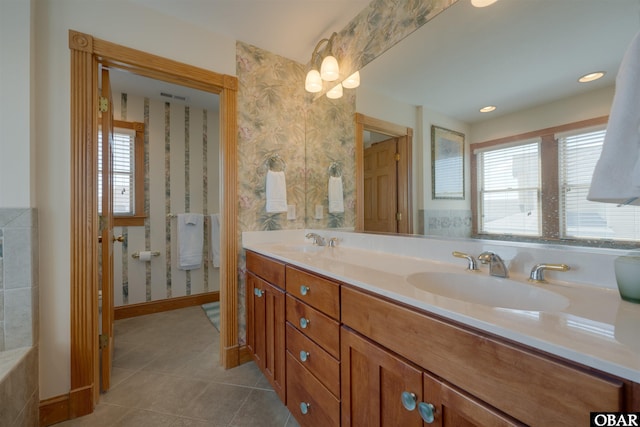 full bath with tile patterned floors, wallpapered walls, double vanity, and a sink