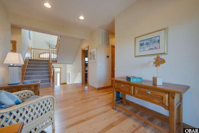 living area with stairs, recessed lighting, baseboards, visible vents, and wood finished floors