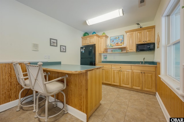 1278 Bear Foot Path Lot 250, Corolla, NC 27927 - kitchen featuring black appliances, a kitchen bar, a peninsula, a sink, and open shelves
