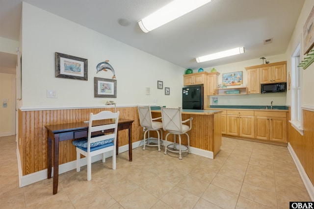 1278 Bear Foot Path Lot 250, Corolla, NC 27927 - kitchen with black appliances, a sink, a kitchen bar, light brown cabinets, and wooden walls
