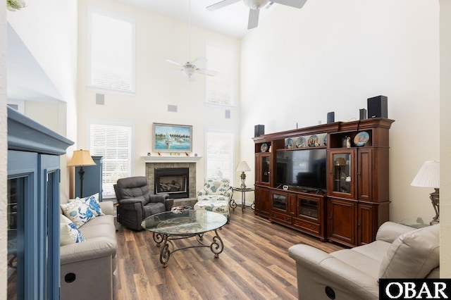 830 Hunt Club Dr Lot 387R, Corolla, NC 27927 - living room featuring a ceiling fan, a high ceiling, wood finished floors, and a fireplace