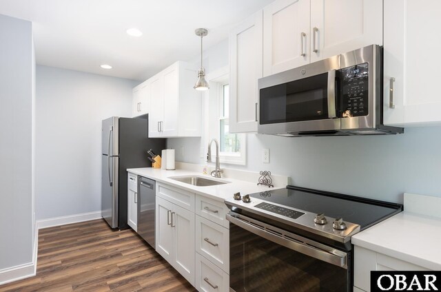 830 Hunt Club Dr Lot 387R, Corolla, NC 27927 - kitchen featuring a sink, dark wood finished floors, stainless steel appliances, decorative light fixtures, and white cabinetry