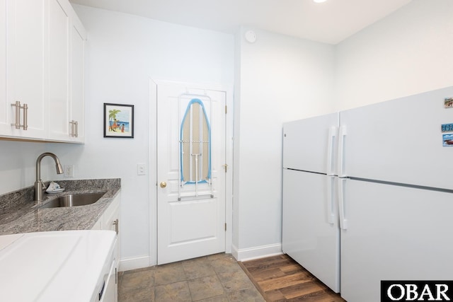 830 Hunt Club Dr Lot 387R, Corolla, NC 27927 - kitchen featuring freestanding refrigerator, baseboards, white cabinetry, light stone counters, and a sink