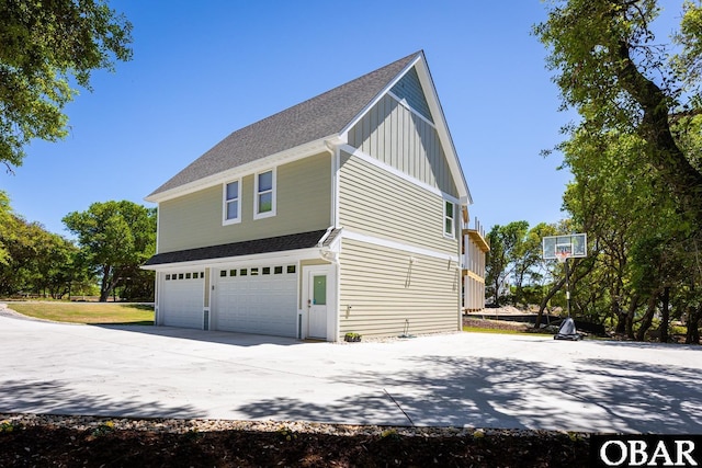 830 Hunt Club Dr Lot 387R, Corolla, NC 27927 - view of side of property featuring a garage, board and batten siding, a shingled roof, and driveway