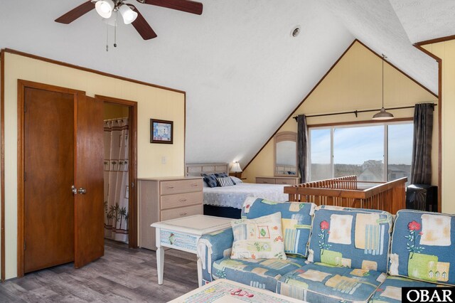 bedroom featuring lofted ceiling, ceiling fan, a textured ceiling, and wood finished floors