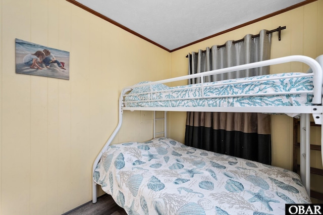 bedroom featuring lofted ceiling, crown molding, and wood finished floors