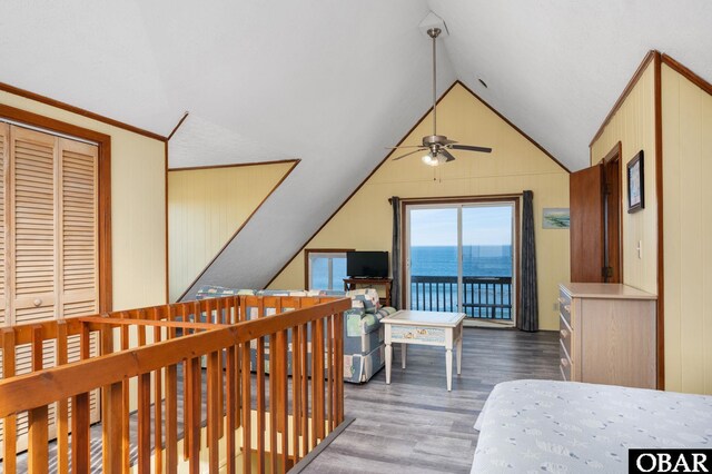 bedroom featuring access to exterior, vaulted ceiling, and wood finished floors