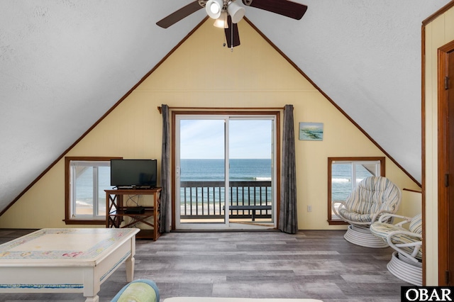 interior space featuring lofted ceiling, crown molding, a wealth of natural light, and wood finished floors