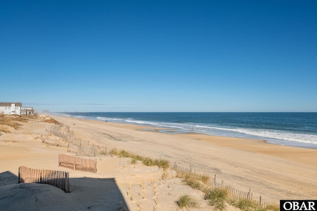 property view of water with fence and a beach view