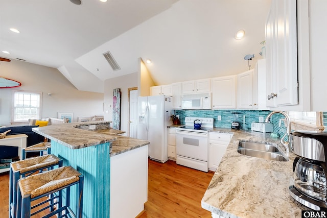 25224 Mac Oca Dr Lot 24, Waves, NC 27982 - kitchen featuring white appliances, a breakfast bar, white cabinetry, light wood-style floors, and backsplash