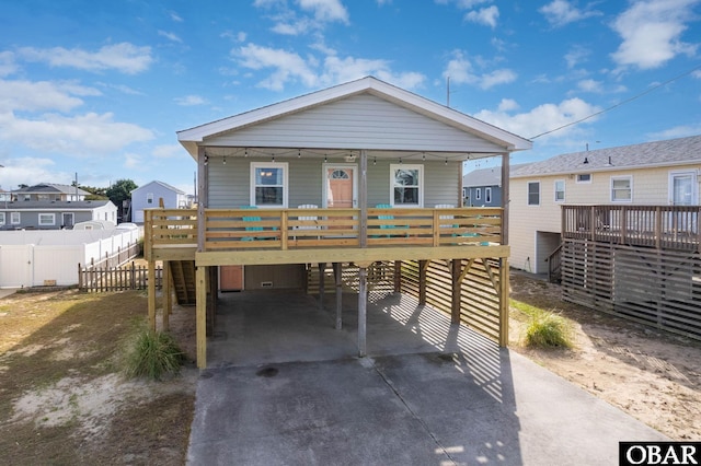 view of front facade featuring driveway, covered porch, and a carport