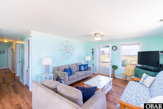 living room with ornamental molding, wood finished floors, and baseboards