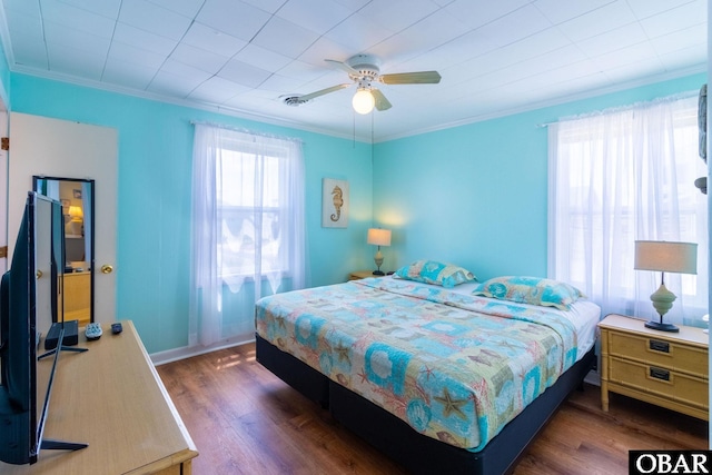 bedroom featuring dark wood-style floors, baseboards, ornamental molding, and ceiling fan