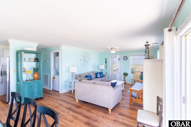 living area featuring a ceiling fan, a healthy amount of sunlight, visible vents, and wood finished floors