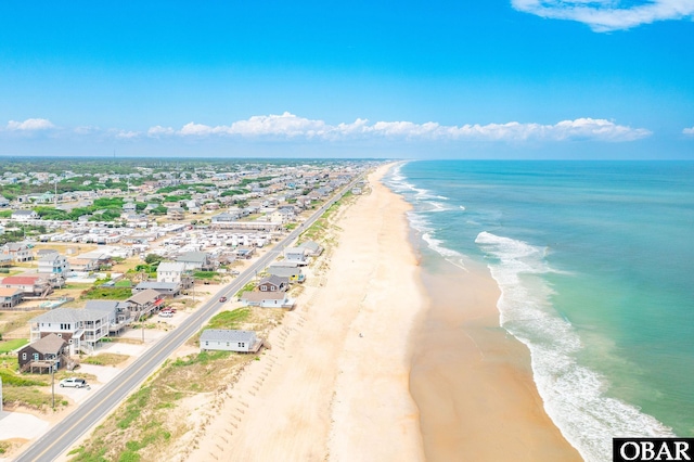 drone / aerial view featuring a beach view and a water view