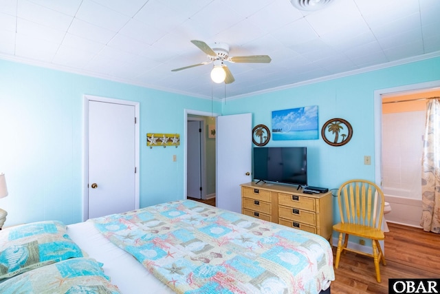 bedroom with wood finished floors, a ceiling fan, and crown molding