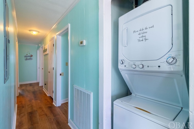 washroom featuring stacked washer and dryer, visible vents, and dark wood-style flooring