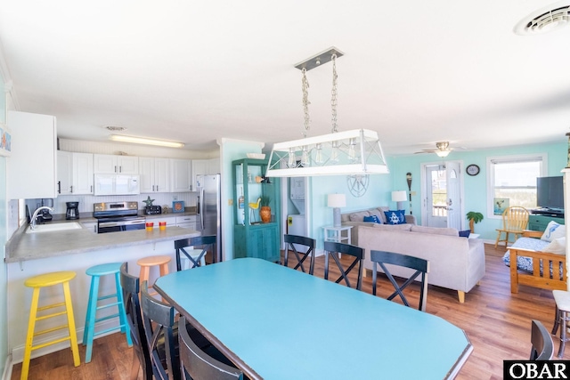 dining area with wood finished floors, visible vents, and a ceiling fan