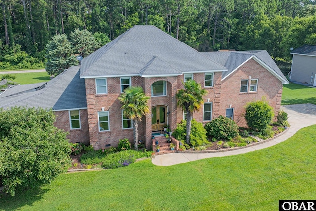 118 Neversail Way Lot 17, Coinjock, NC 27923 - view of front facade featuring a shingled roof, a front yard, brick siding, crawl space, and a forest view