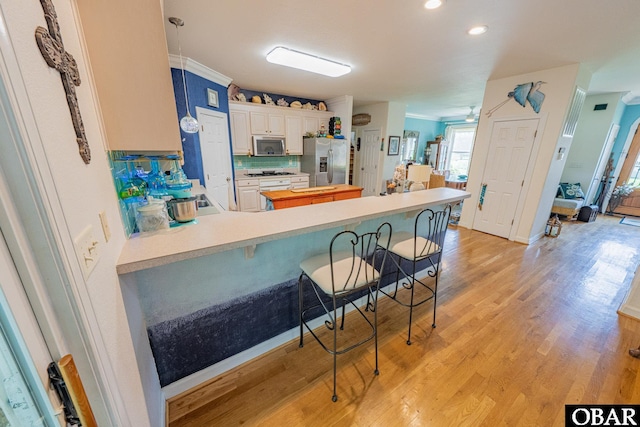 118 Neversail Way Lot 17, Coinjock, NC 27923 - kitchen featuring stainless steel appliances, a breakfast bar, a peninsula, light wood-type flooring, and recessed lighting