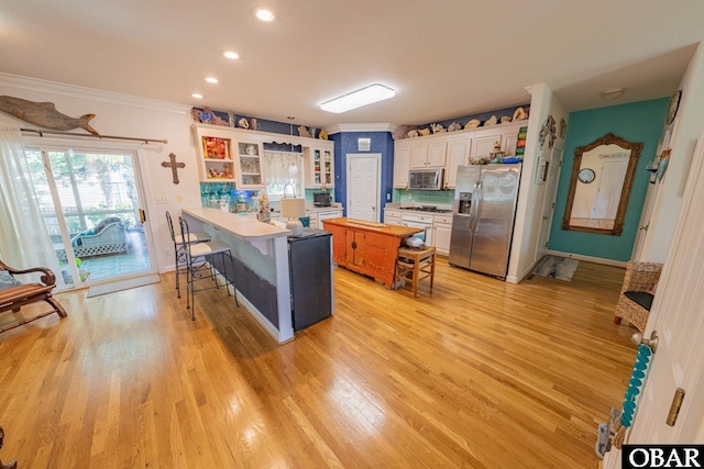 118 Neversail Way Lot 17, Coinjock, NC 27923 - kitchen with stainless steel appliances, a peninsula, a kitchen breakfast bar, glass insert cabinets, and light wood-type flooring