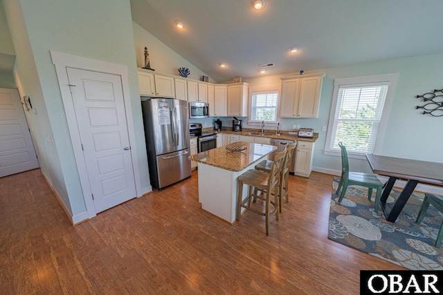 26223A Bluebeard Rd Lot 88, Salvo, NC 27972 - kitchen featuring appliances with stainless steel finishes, a sink, white cabinetry, light stone countertops, and lofted ceiling