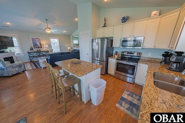 26223A Bluebeard Rd Lot 88, Salvo, NC 27972 - kitchen featuring appliances with stainless steel finishes, open floor plan, a sink, lofted ceiling, and light wood finished floors