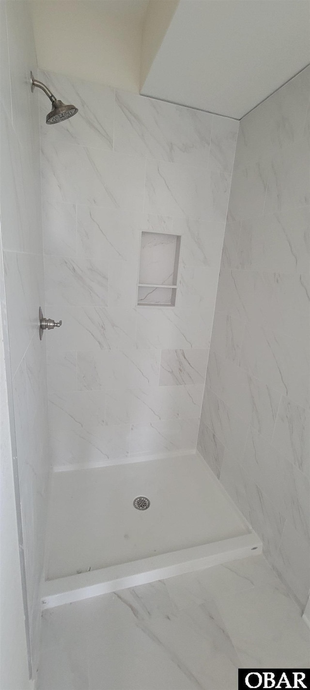 bathroom featuring a shower and marble finish floor