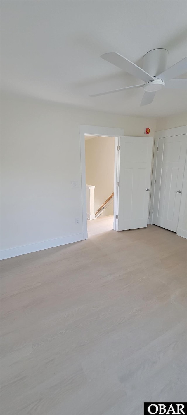 empty room featuring a ceiling fan and baseboards